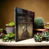 Zwart hardcover boek Rechtgeleide Kaliefen van Mahmoed Shakir omringd door succulentplanten